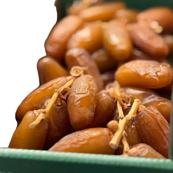 Box of dates with a green lid and visible barcode on a blurred background